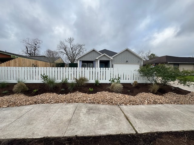 A Houston family and HGTV professionals gazing at a 76 Fence West Houston installed horizontal privacy fence on HGTV's Worst Yard on the Block.