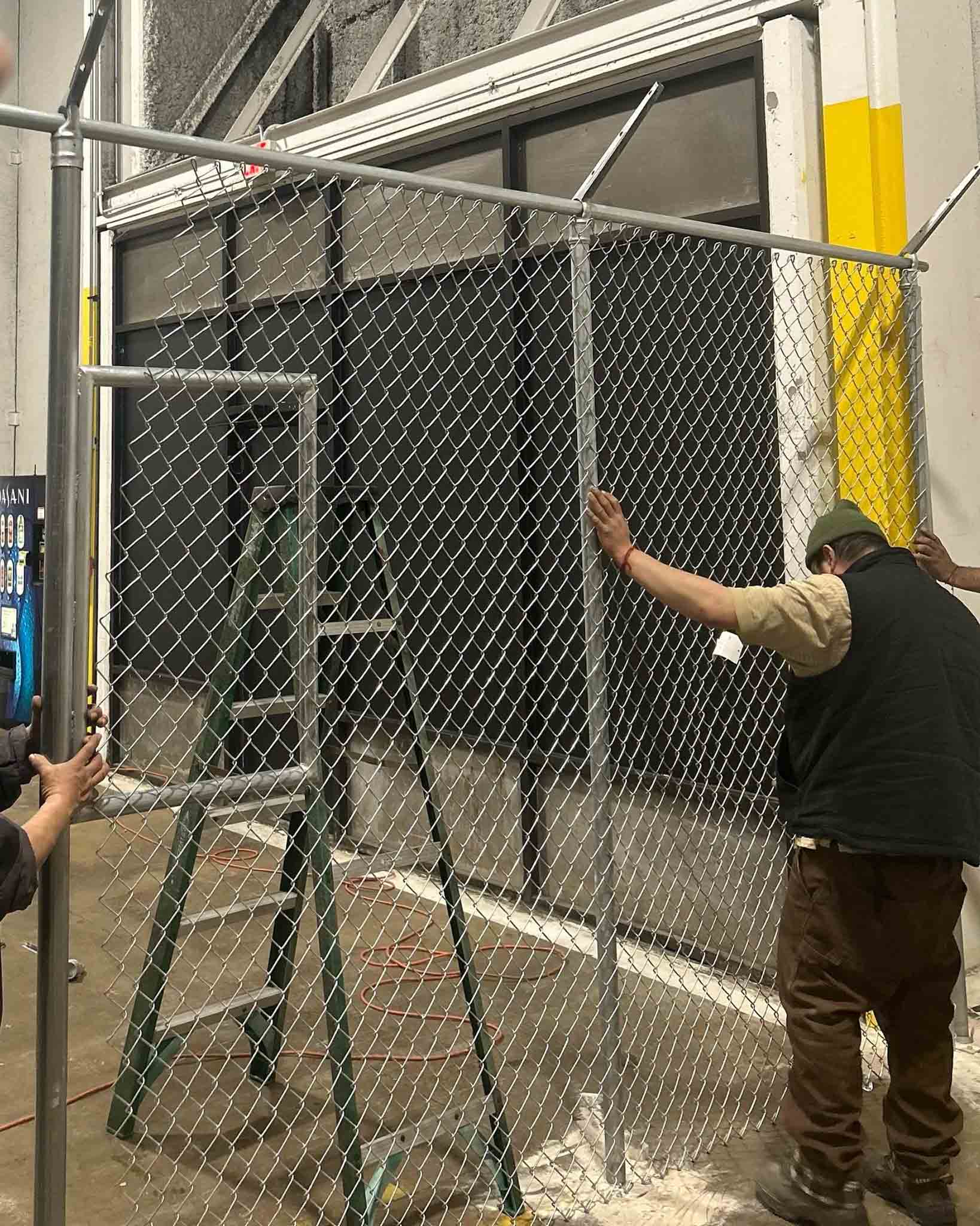 A 76 FENCE expert installing a chain link fence.