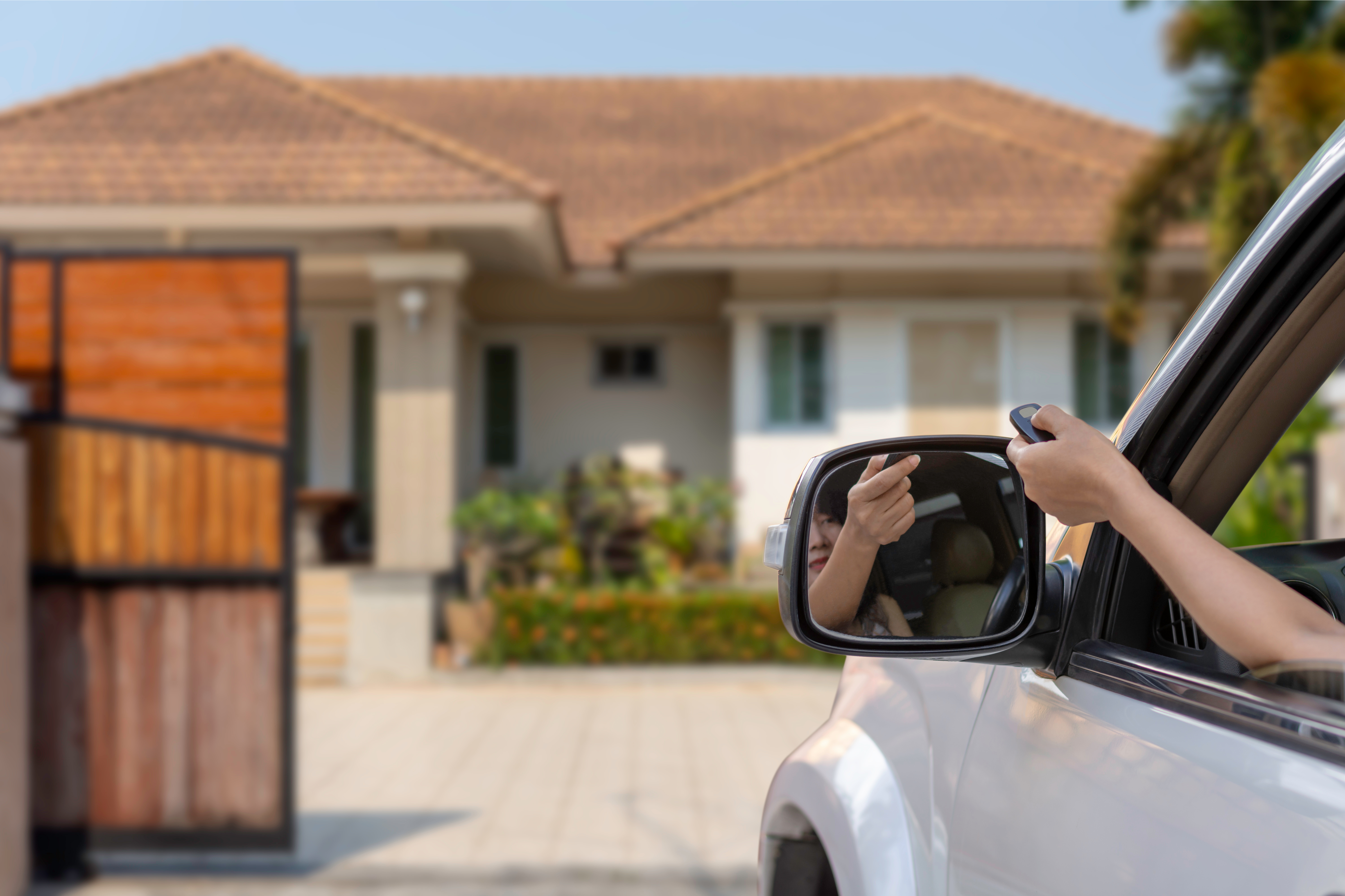 Someone in a car using a remote to open their electric security gate - contact 76 Fence, the premier company to install electric gates in Douglasville, GA.