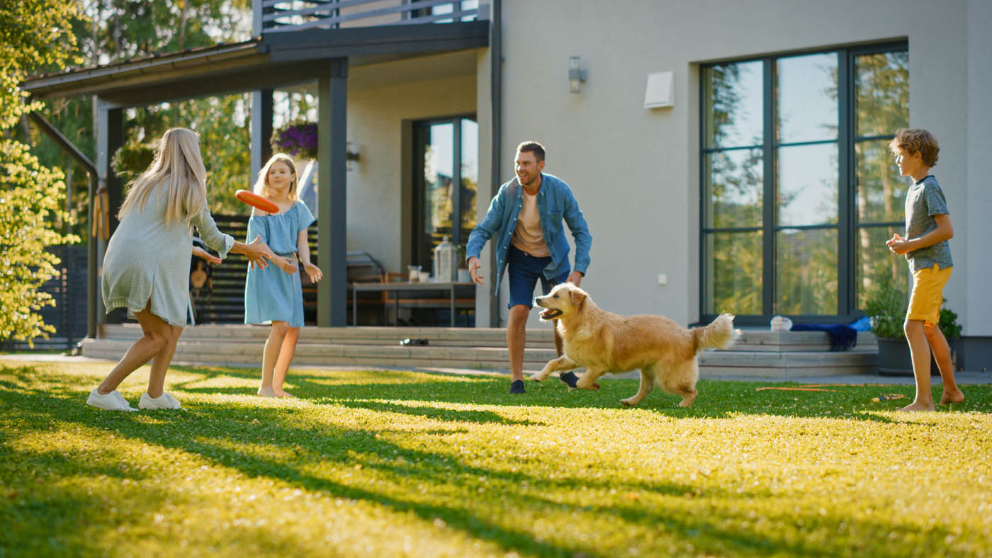 A family playing with their dog in a newly fenced backyard, contact us today as one of the leading fence contractors in Charlotte, NC.