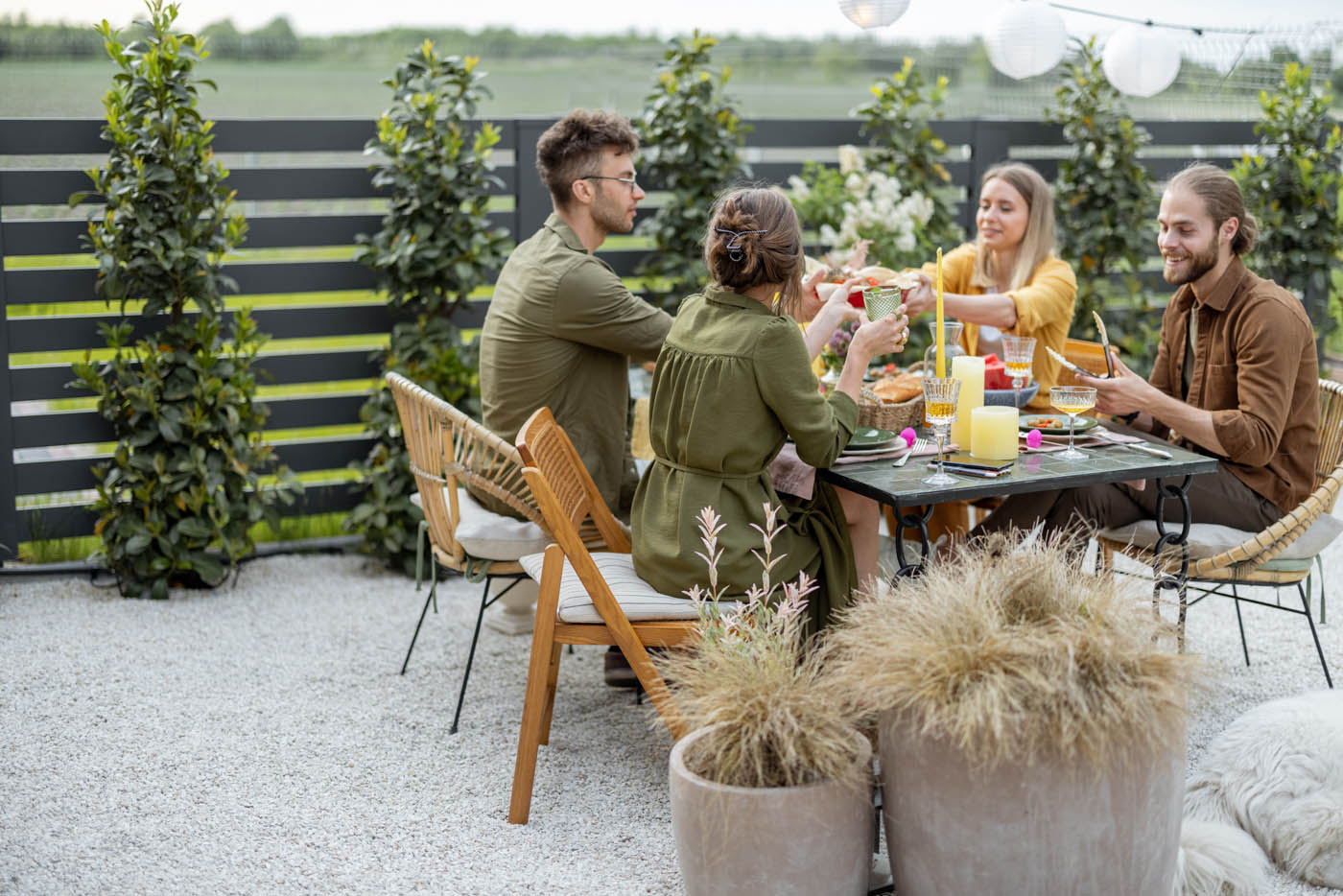 A family eating an outside meal next to their 76 FENCE North Nashville steel fence.