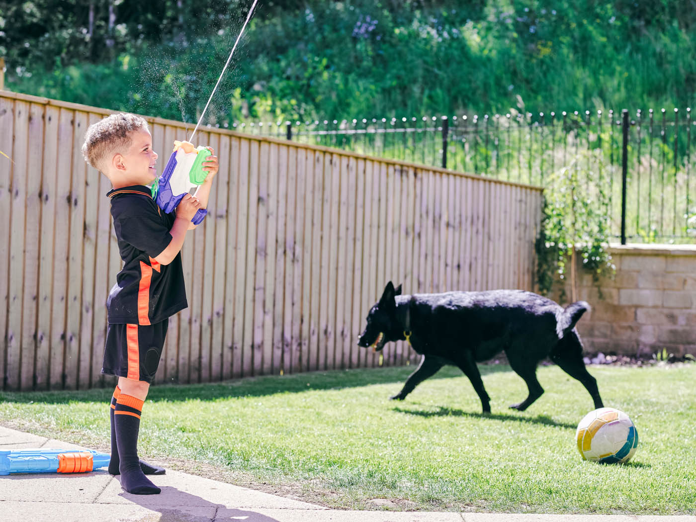 A boy playing outside with his dog - learn more about pine fences in Mt. Juliet, TN with 76 FENCE.