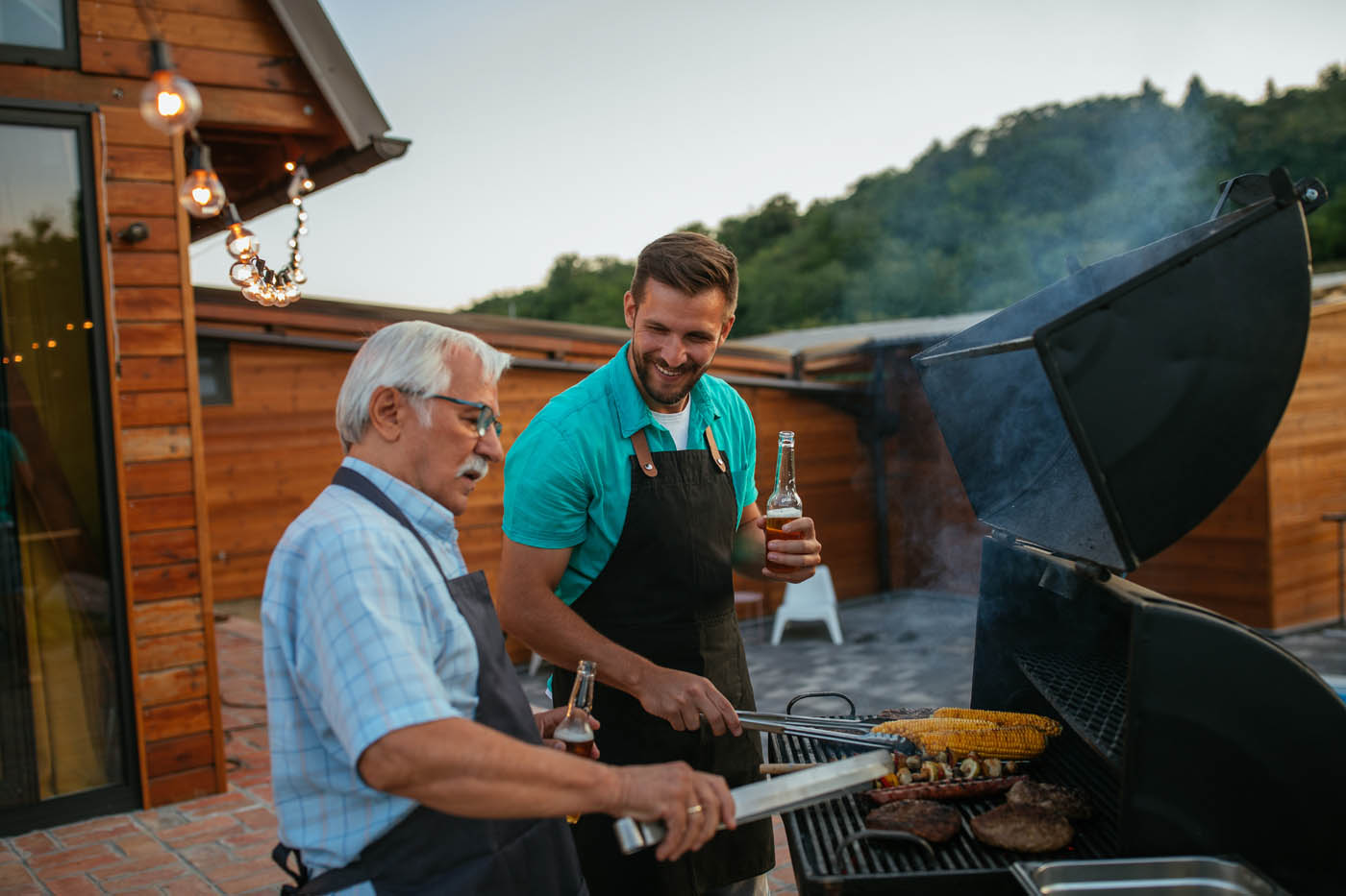 A father and son cooking on a grill outside, choose 76 FENCE Mt. Juliet fencing.