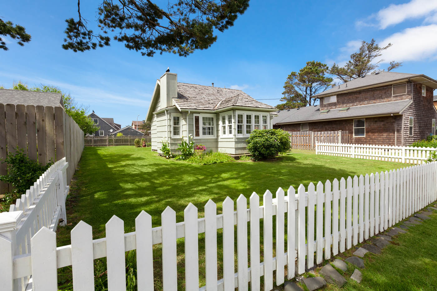 A small chunk of property with a white picket fence - learn more about our picket fence installation in Hendersonville / Gallatin, TN.