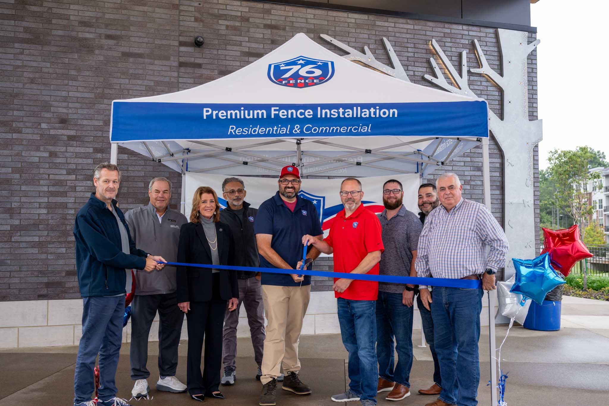 An image of the 76 Fence Greater Cincinnati owners and team members cutting their grand opening ribbon.
